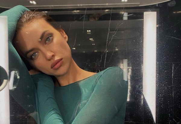 Ирина Шейк в ванной команте в зеленой кофте смотрит в зеркало Ирина Шейк в ванной команте в зеленой кофте смотрит в зеркало